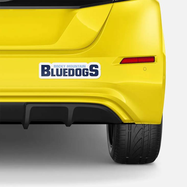 Back of yellow car with bumper sticker attached to the bumper stating Rocky Mountain Bluedogs printed by StickerGiant