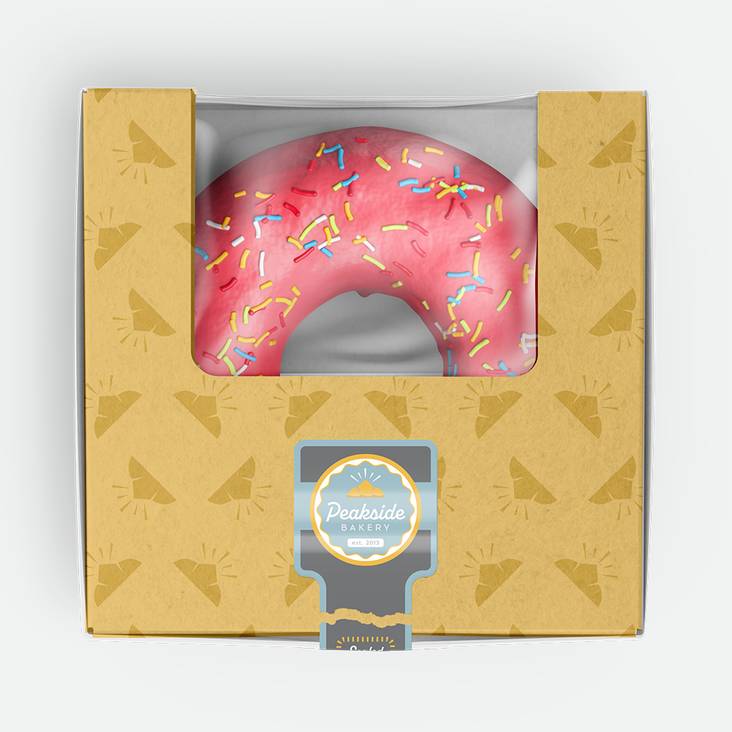 A donut bakery box with Peakside bakery glossy paper label printed by StickerGiant applied to the box sealing it closed