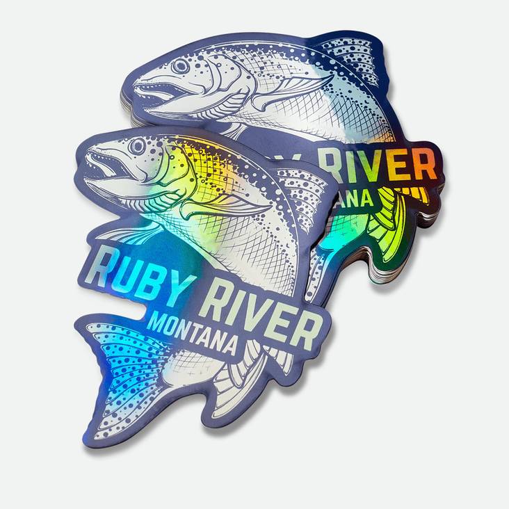 A stack of holographic stickers printed by StickerGiant in the shape of fish, Ruby River Montana logo