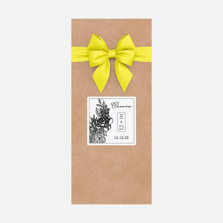 A brown paper gift bag with a square sticker printed by StickerGiant applied to the side